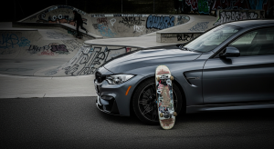 BMW M garée devant un skatepark urbain avec skateboard posé contre la roue - partenariat luxe automobile et street skateboarding