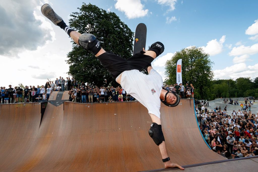 Tony Hawk en handplant sur la mini-rampe de Fælledparken à Copenhague en 2015, devant une foule de jeunes skateurs