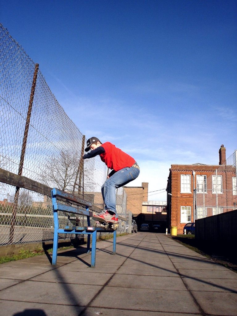 Skateur en 50-50 sur un banc public, les deux trucks verrouillés sur l'arête