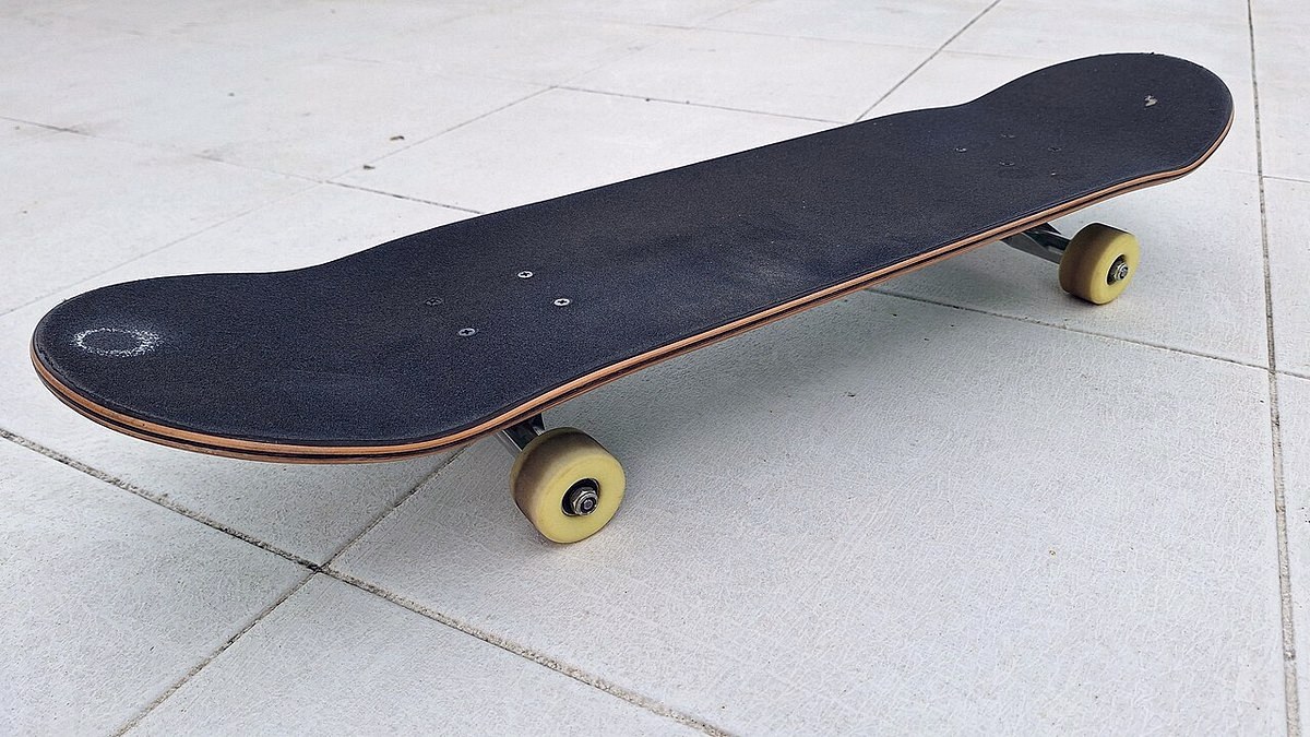 Skateboard vu de dessus avec grip tape noir couvrant toute la surface du deck