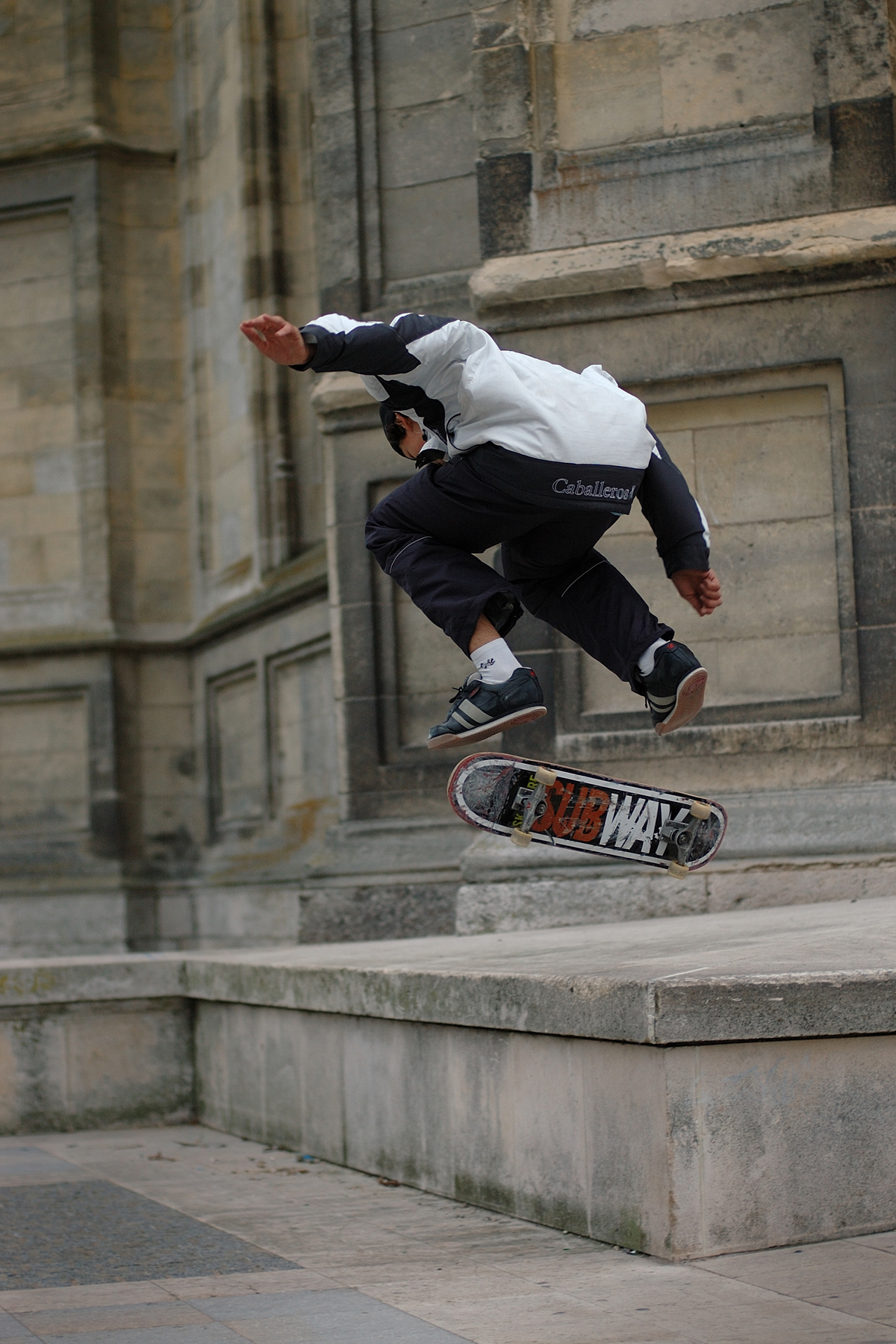 Skateur en plein flip, board en rotation sous ses pieds, devant la cathédrale d'Orléans