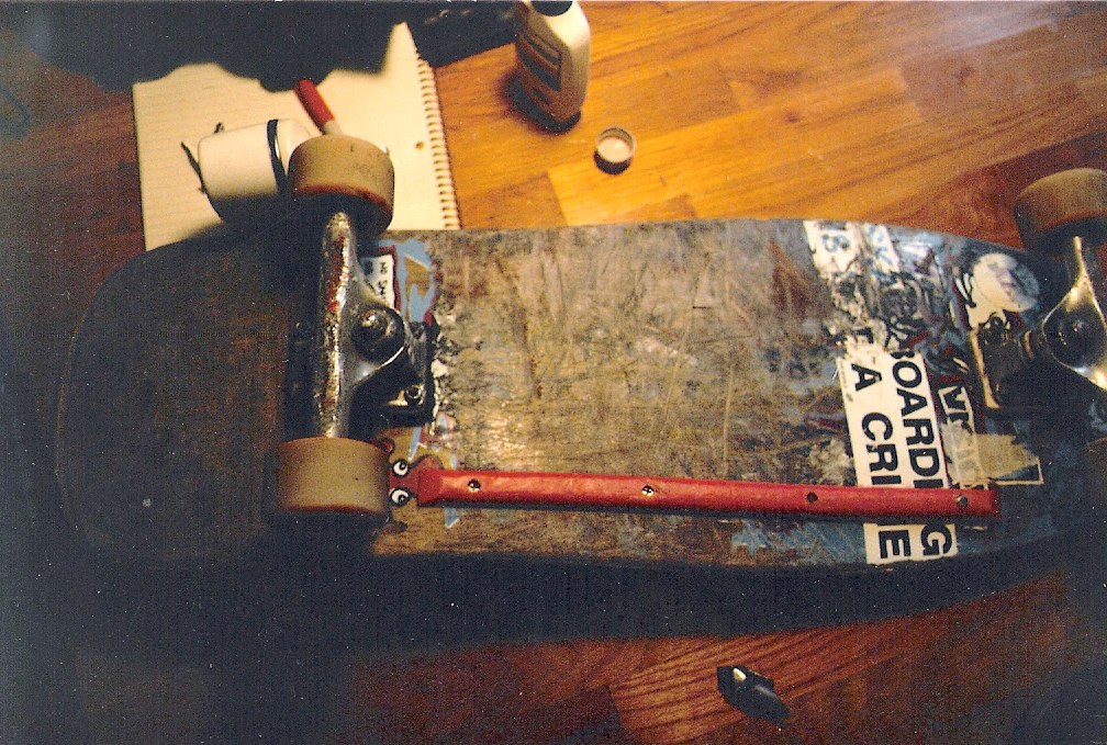 Setup skateboard de 1988 vu du dessus : deck Mark Gonzales usé jusqu’au bois, trucks Venture, sticker Skateboarding Is Not A Crime, photo argentique