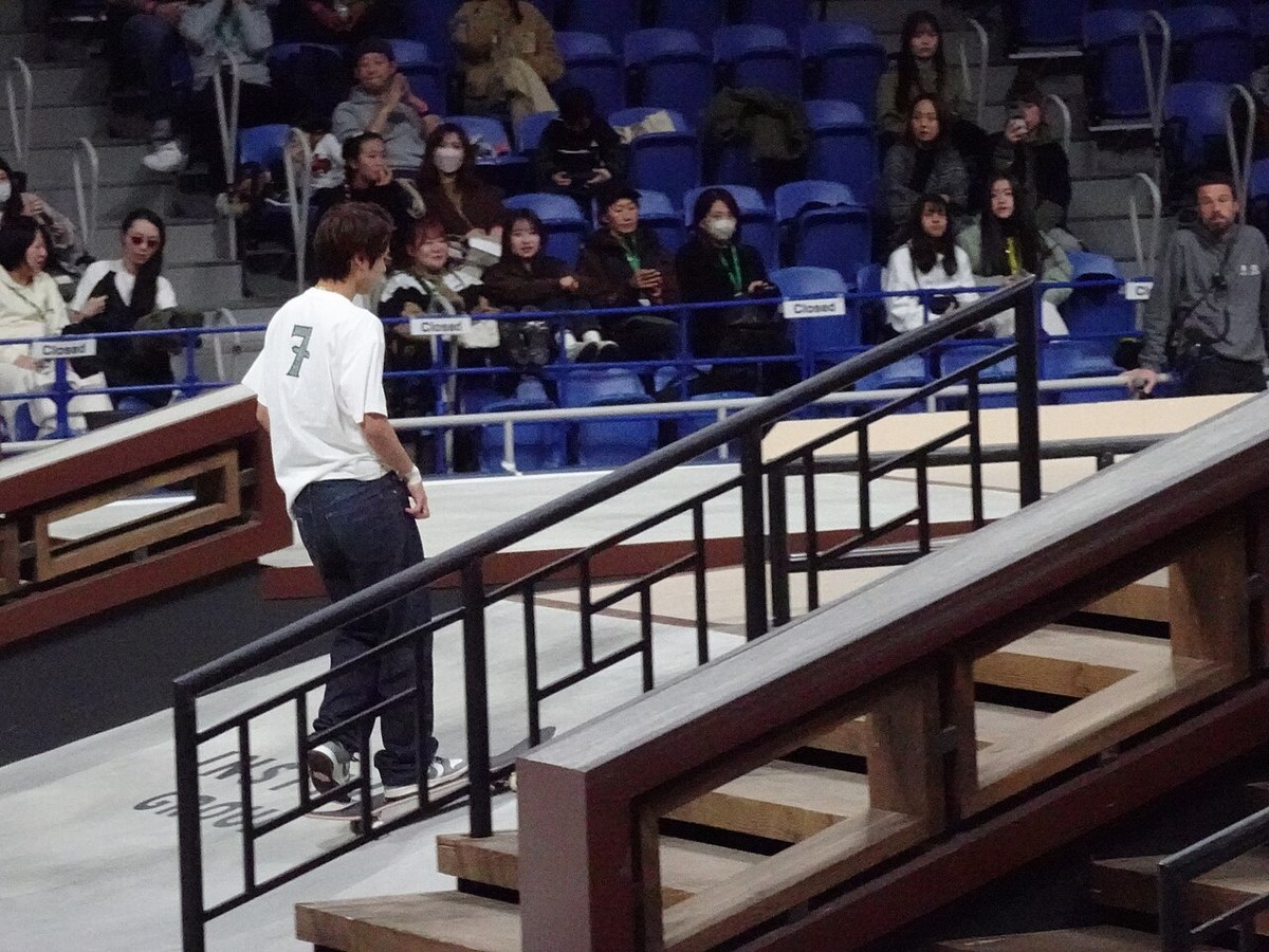 Yuto Horigome de dos, maillot numéro 7, sur le plateau du Championnat du monde de skateboard street à l’Ariake Coliseum de Tokyo en décembre 2023