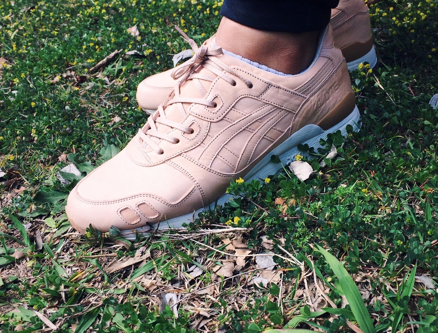 Chaussure ASICS en cuir portée au pied, semelle GEL visible sur le côté