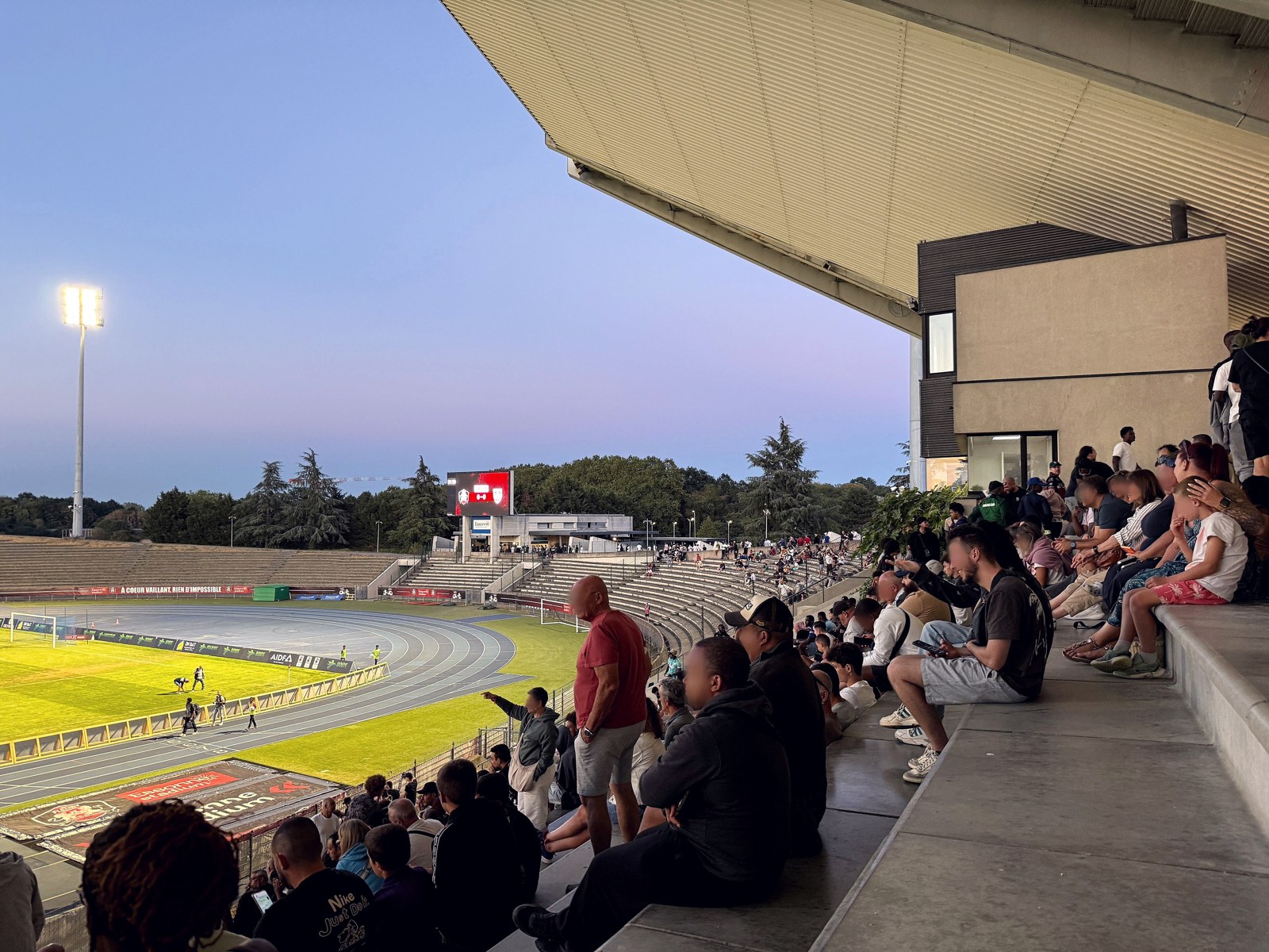 Tribunes de l'Essonne Stadium de Bondoufle au crépuscule, projecteurs allumés