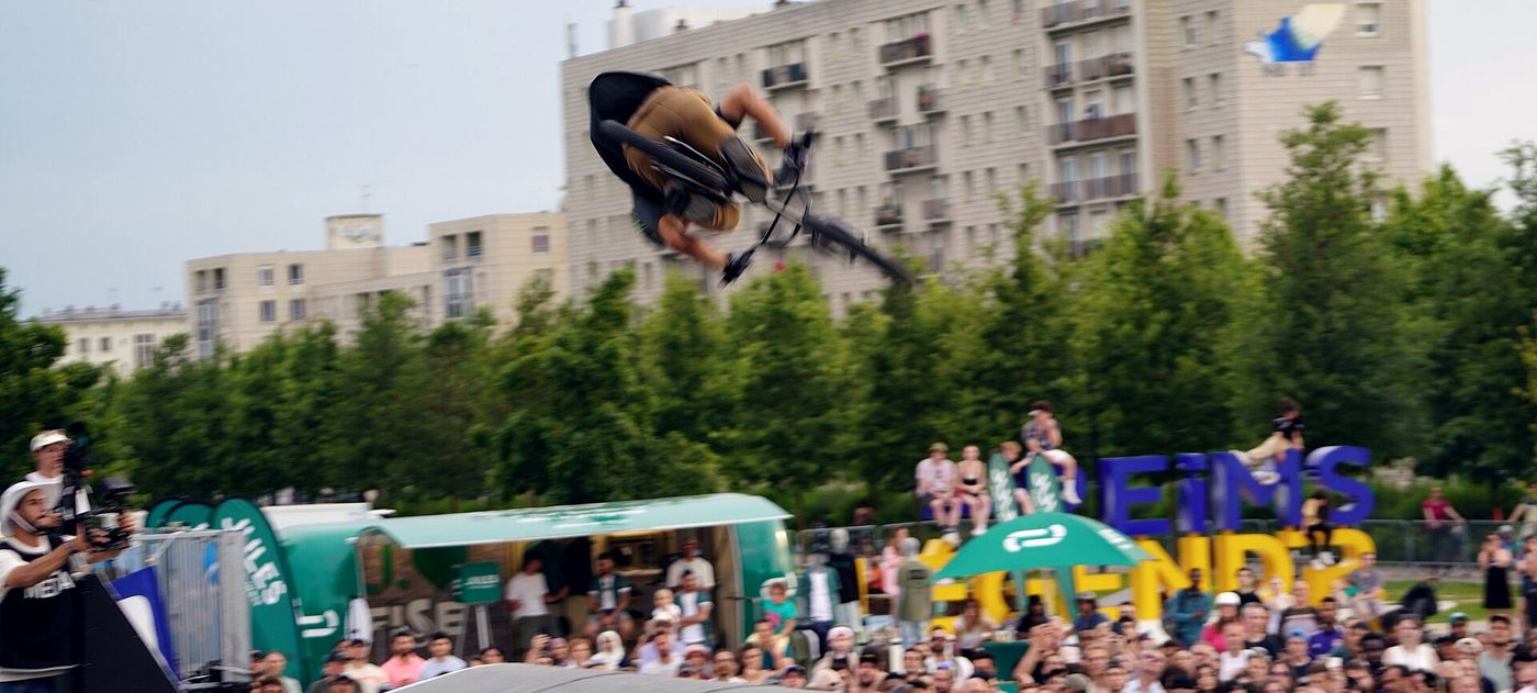 Public compact derrière les barrières d'une étape française du FISE, rider en l'air au-dessus des modules