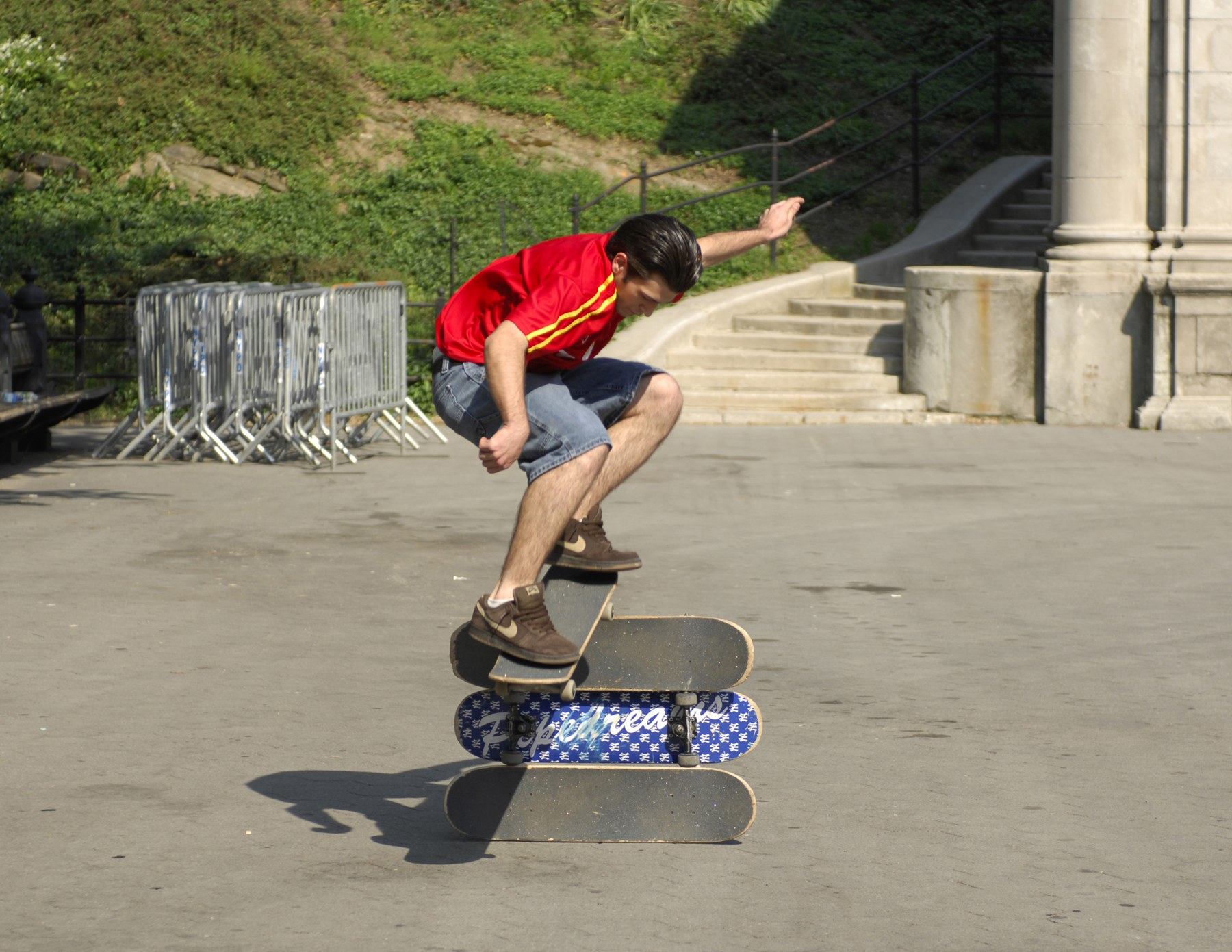 Monter la barre centimètre par centimètre : skateur en l'air au-dessus de trois planches empilées à Central Park