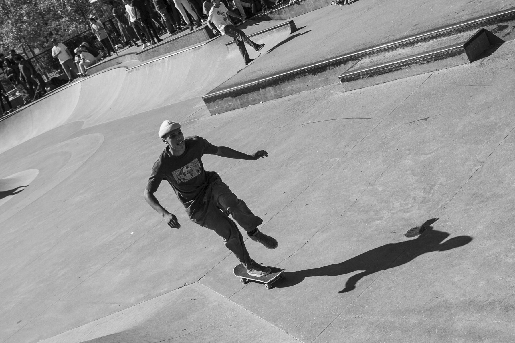 Skateur donnant un gros push au skatepark, regard vers l'avant : la vitesse qui rend le hippie jump possible