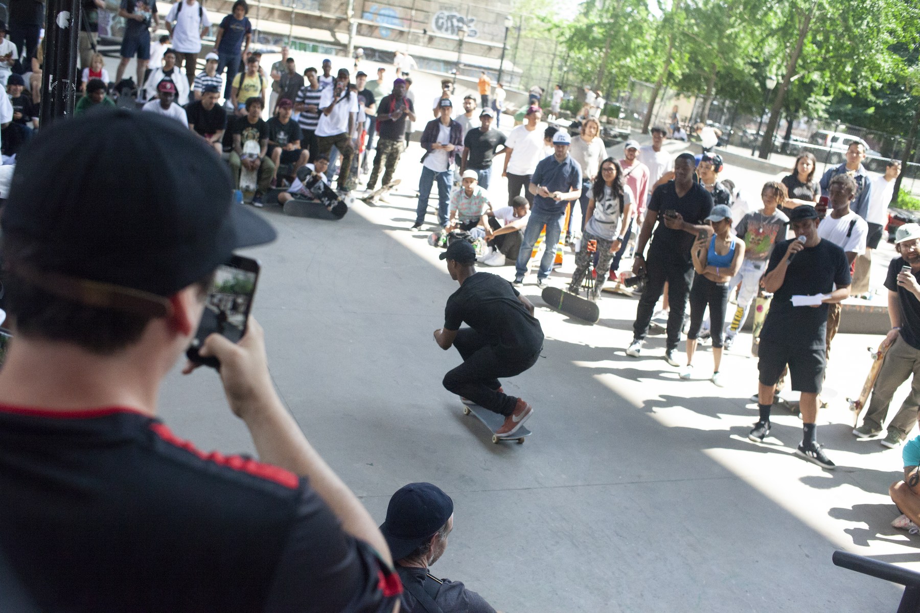 Étape finale du hippie jump : le skateur retombe sur les vis et roule encore, devant la foule du LES skatepark