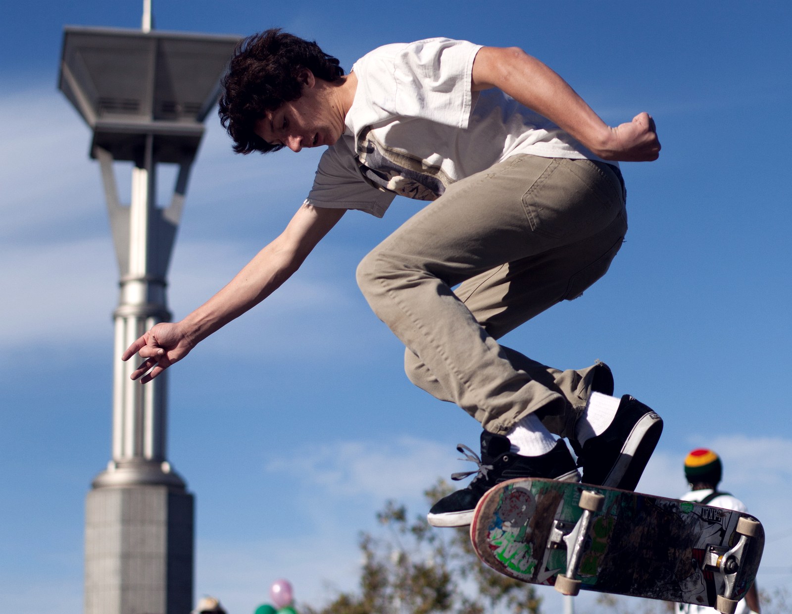 Skateur en plein kickflip sur du plat, planche en rotation sous ses pieds