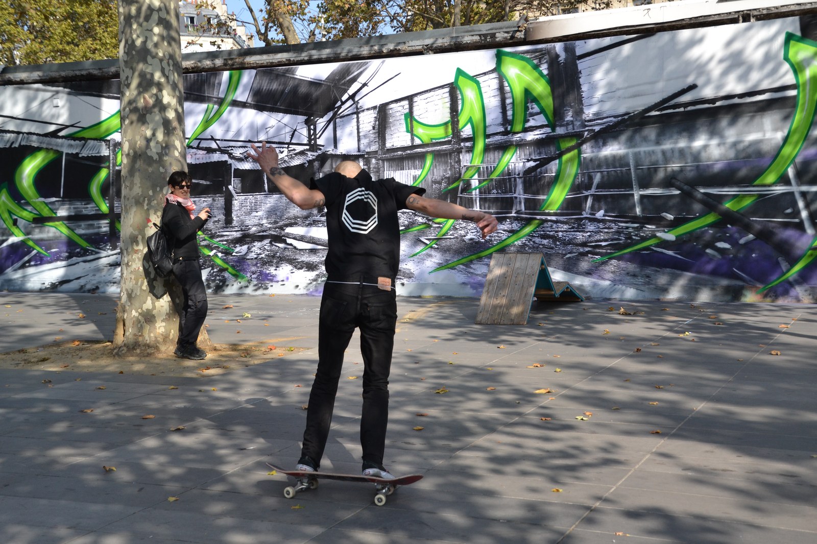 Skateur en équilibre sur sa planche place de la République à Paris devant une fresque
