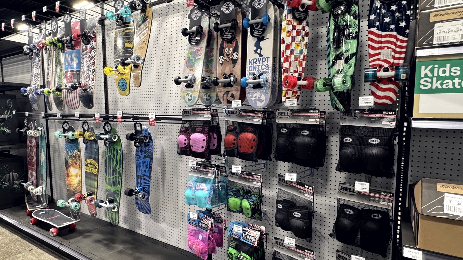 Rayon skate d'une grande surface de sport avec étiquettes de prix sur des skates complets bon marché