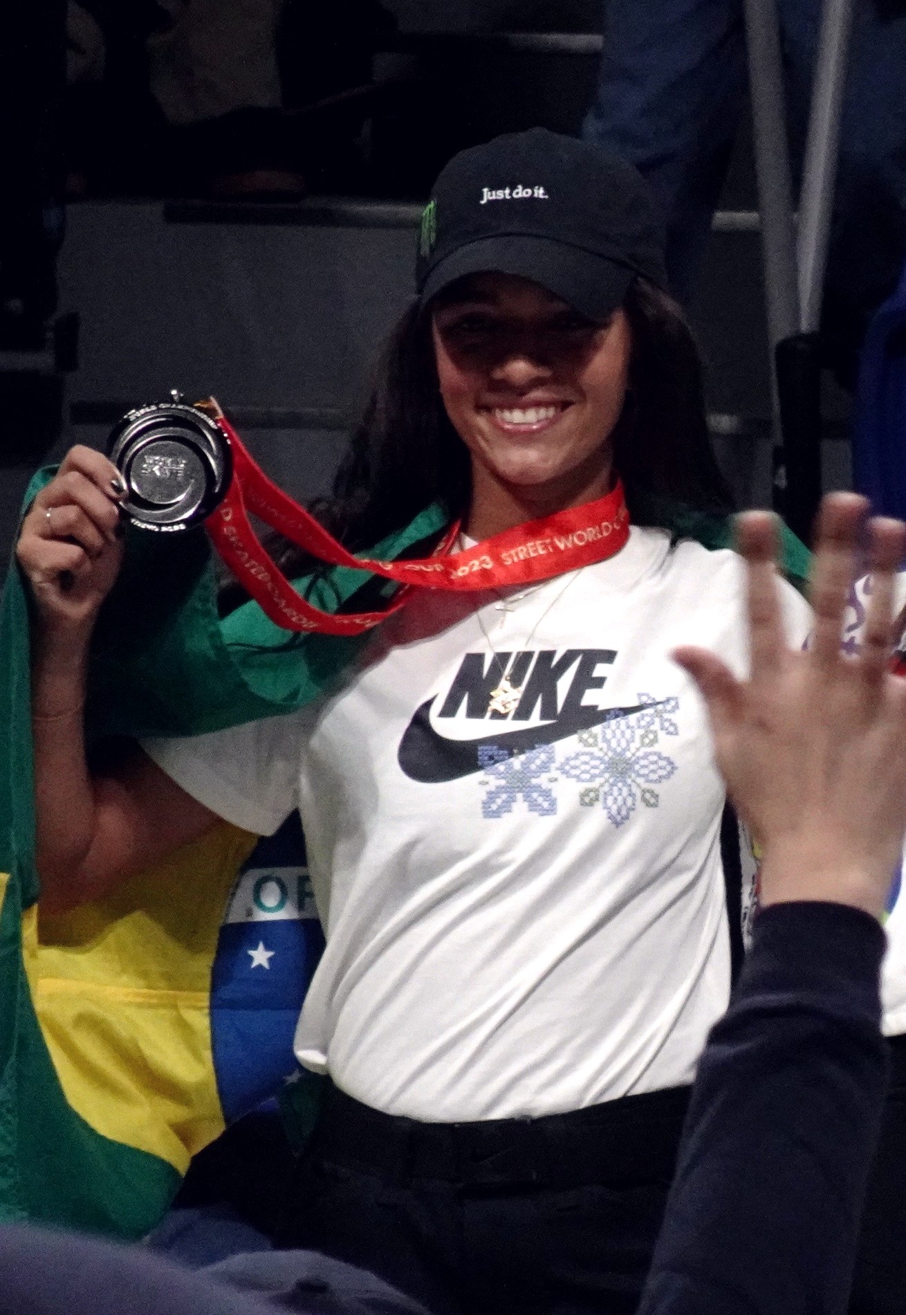 Rayssa Leal brandit sa médaille d'argent, drapeau brésilien sur les épaules, aux Mondiaux de street 2023 à Tokyo