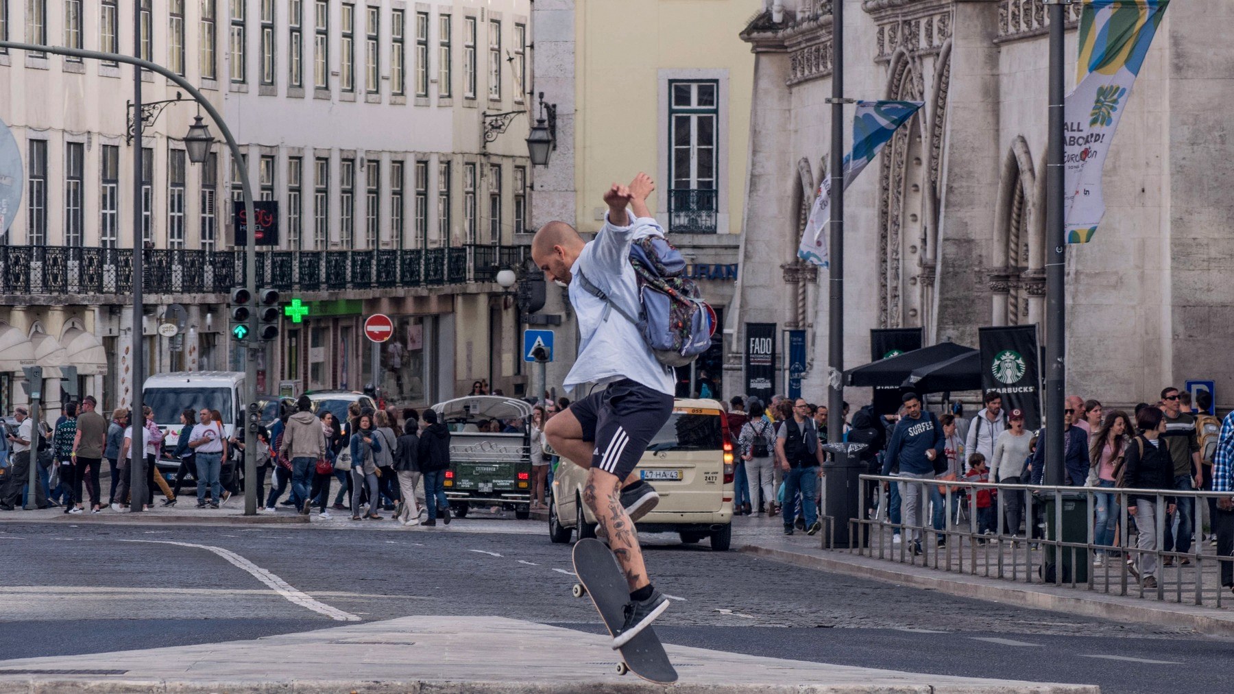 Skateur en ollie au milieu d un passage piéton à Lisbonne, sac à dos sur le dos