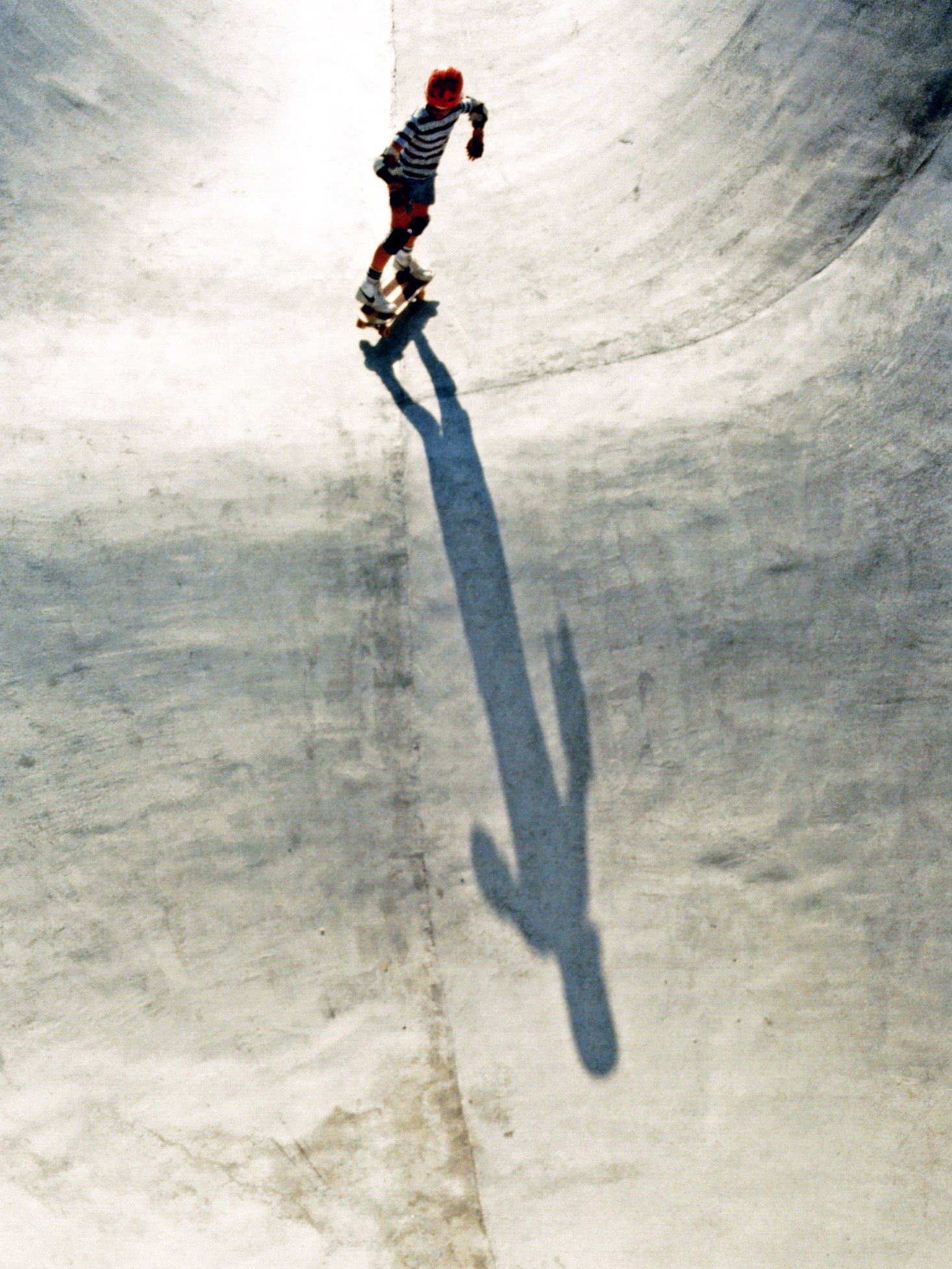 Skateur descendant la paroi d&rsquo;un bowl en béton au skatepark de Carson en Californie en 1978