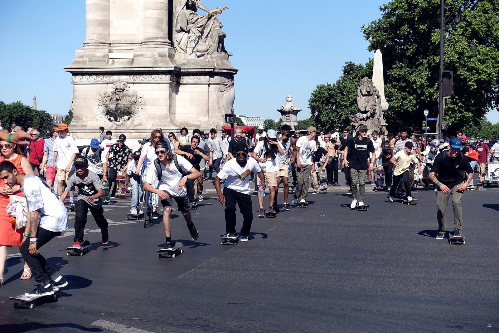 Groupe de skateurs roulant ensemble sur la chaussée au pied du pont Alexandre III à Paris