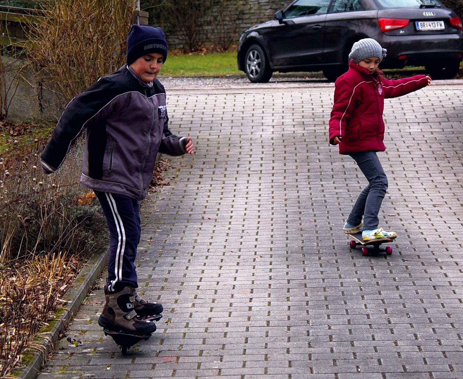 Deux enfants qui roulent dans la rue sur leur première planche de skateboard