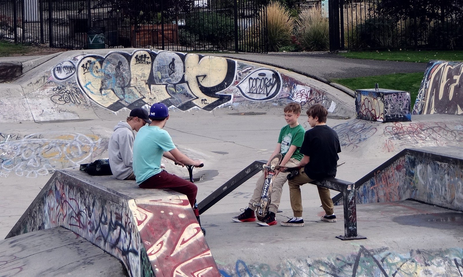 Enfants au skatepark, un skateboard posé debout à côté d'eux