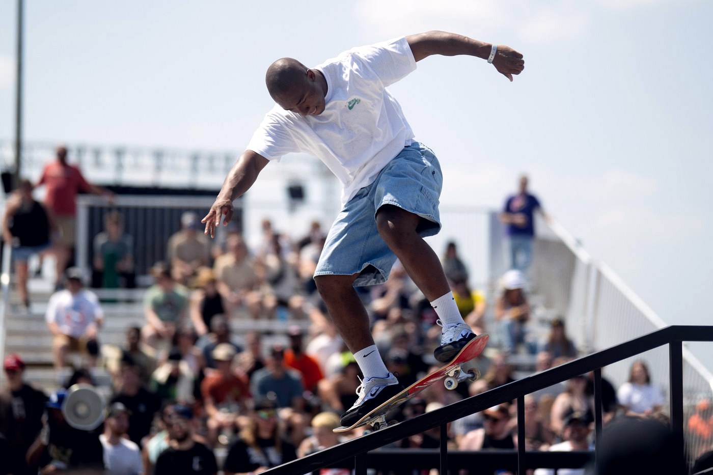 Skateur en grind sur un rail lors d'une étape du Street League Skateboarding devant les tribunes