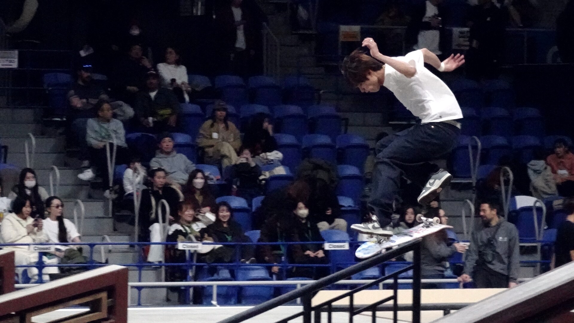Yuto Horigome en l'air au-dessus d'un handrail aux championnats du monde de street à Tokyo, décembre 2023