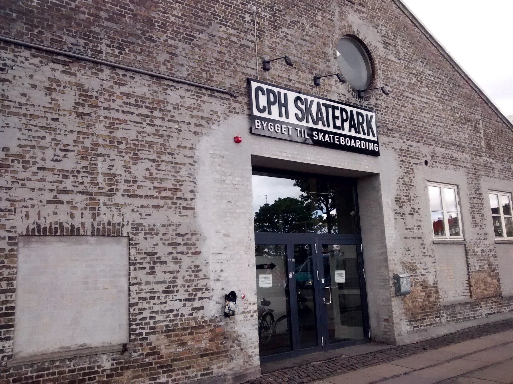 CPH Skatepark à Copenhague : ancien hangar en brique dont l'enseigne annonce « bygget til skateboarding »