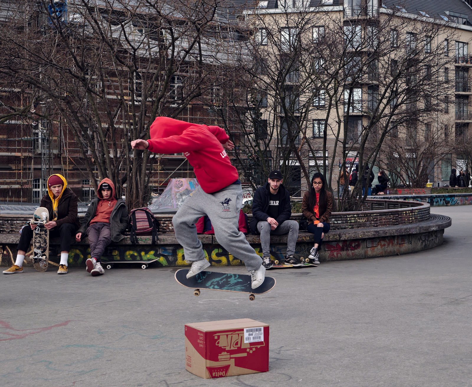 Riders assis sur le bord du module qui regardent un skateur envoyer son trick, au moment ou se joue le ticket pour Tampa