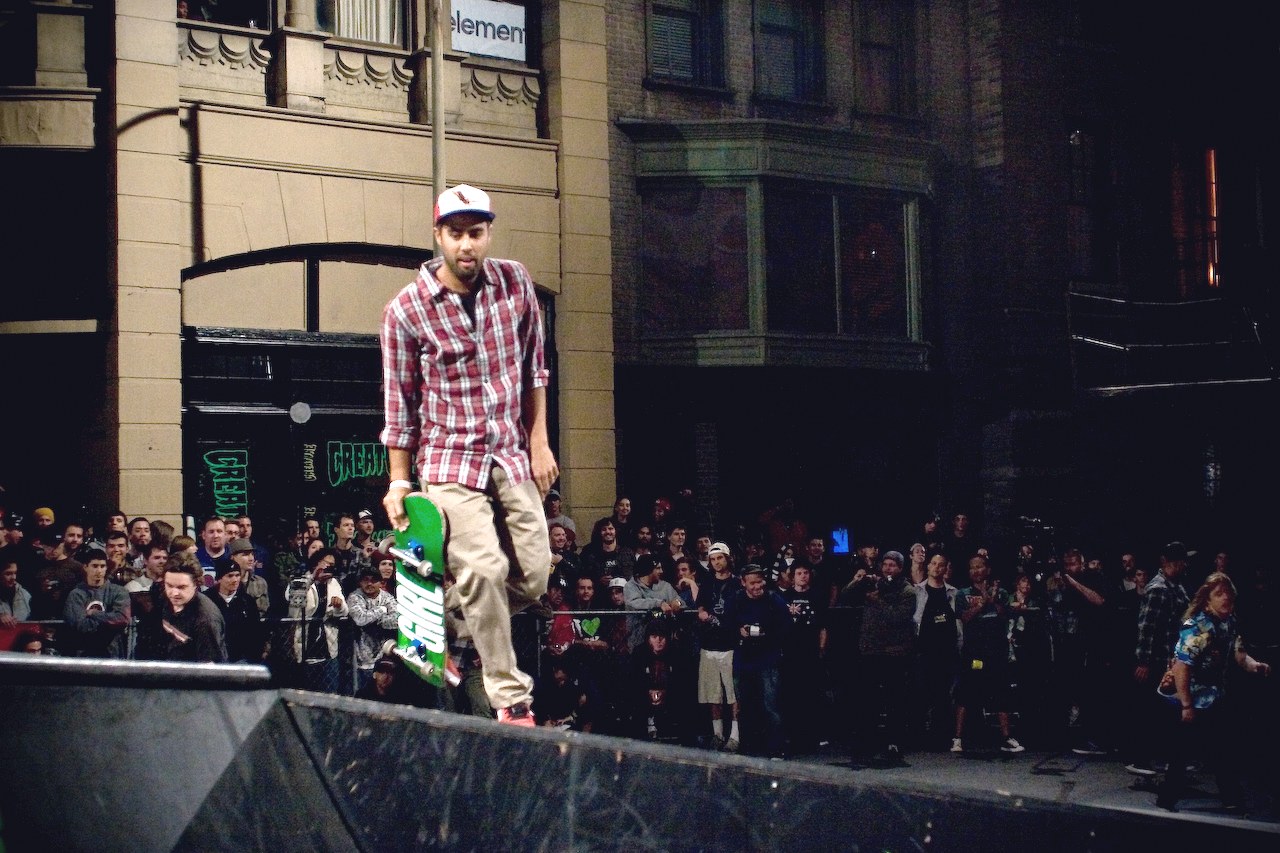 Eric Koston, planche Girl verte en main, sur la rampe du Vans Downtown Showdown en 2008, devant la foule