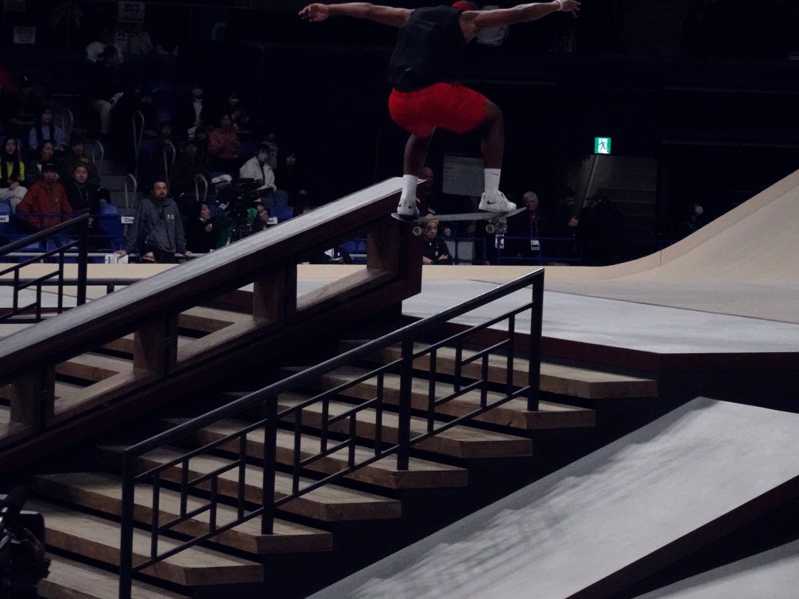 Finale street : un skateur passe le handrail au-dessus des marches pendant un run de contest