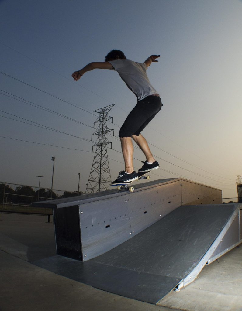 Frontside nosegrind sur un ledge : truck avant seul, planche alignée, zéro angle