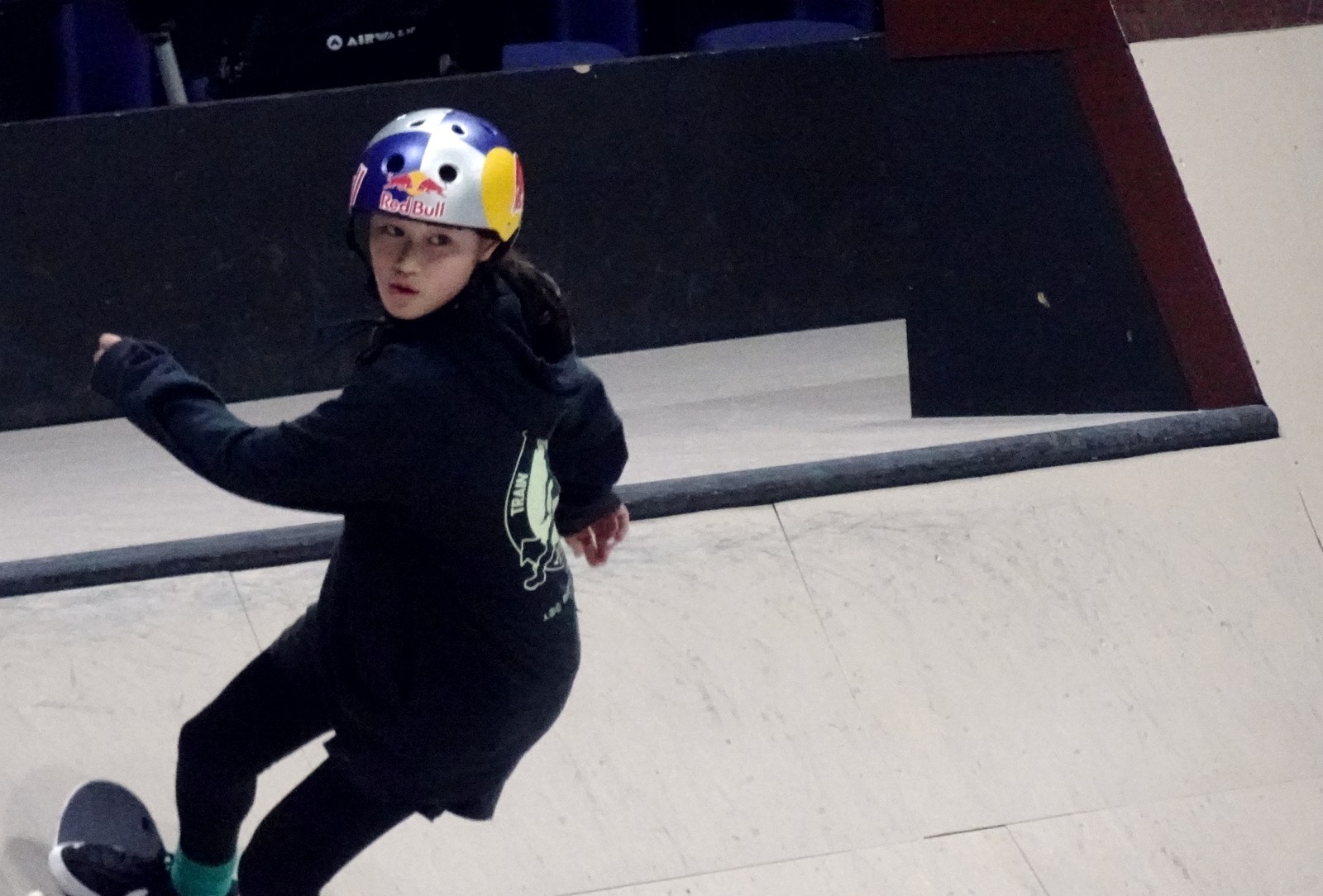 Jeune skateur japonais casqué sur sa planche avant une finale de street