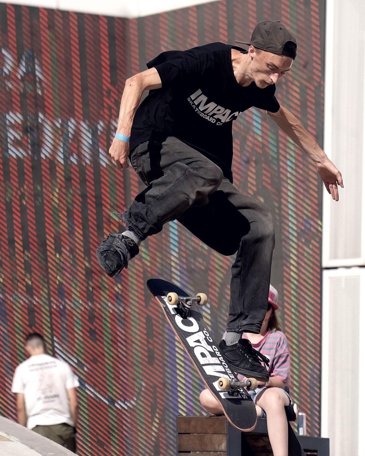 Skateur en plein flip trick, pied avant qui vient de flicker le bord et planche en rotation — le geste du heelflip