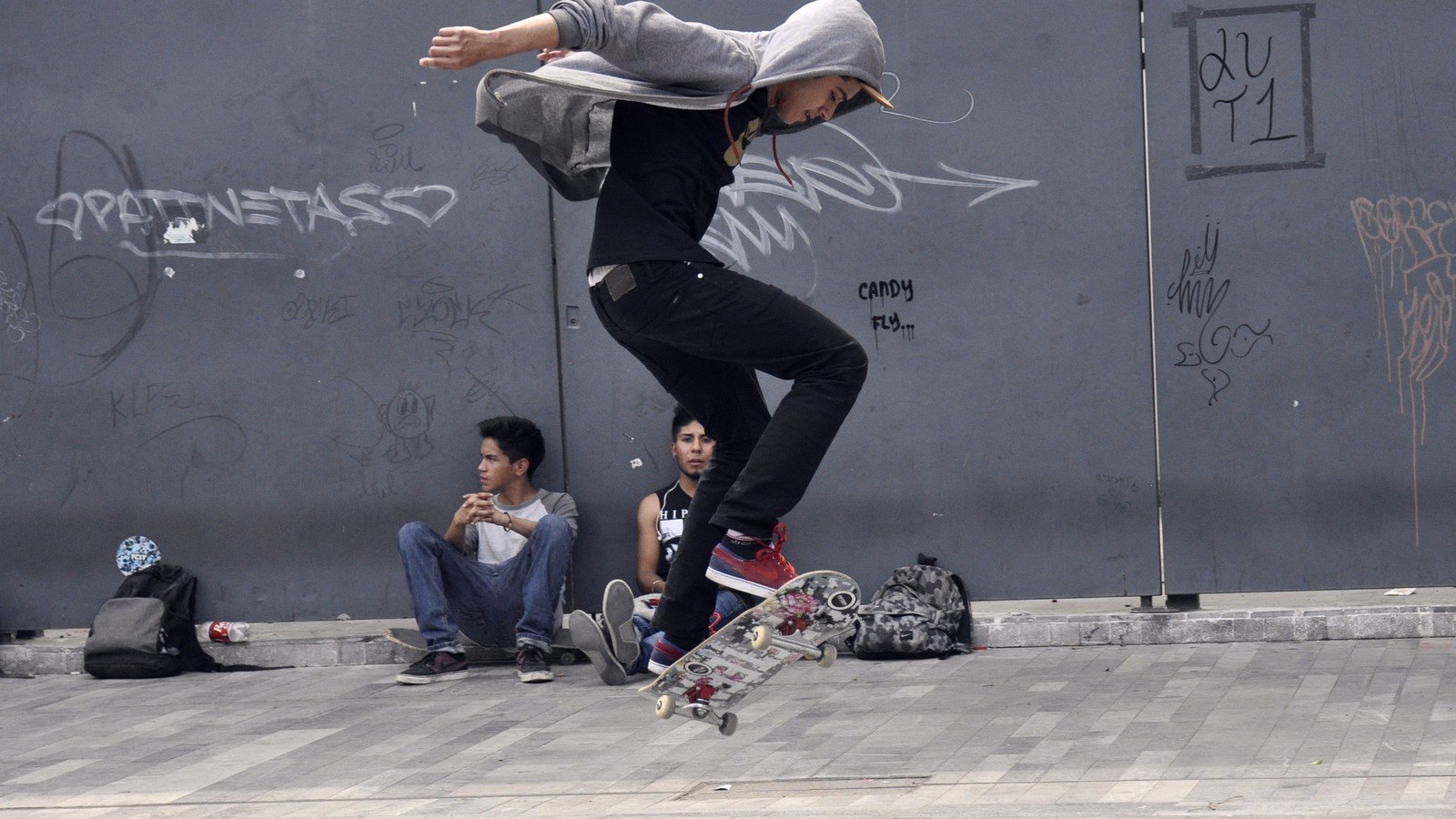 Skateur en l'air, planche en pleine rotation sous ses pieds pendant un flip
