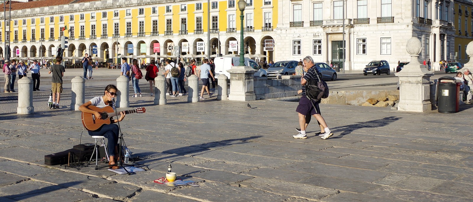 Touristes traversant les grandes dalles de pierre de la Praça do Comércio à Lisbonne