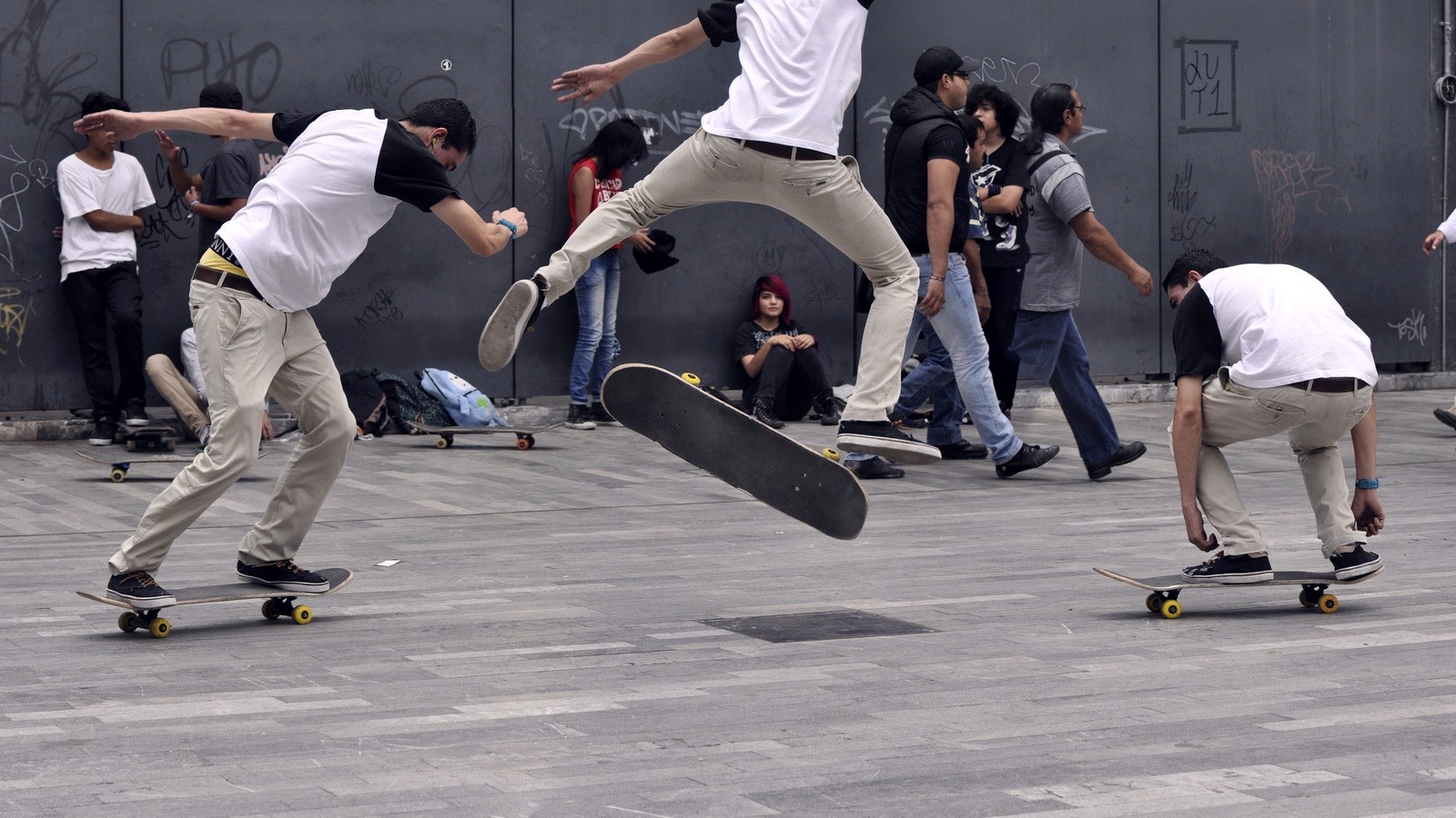 Trois phases d'un flip décomposé : appui sur le tail, planche en rotation en l'air, réception