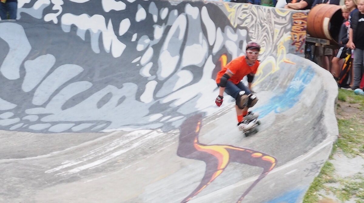 Skateur adulte casqué et protégé qui roule dans un bowl, bien après la première semaine de reprise du skate