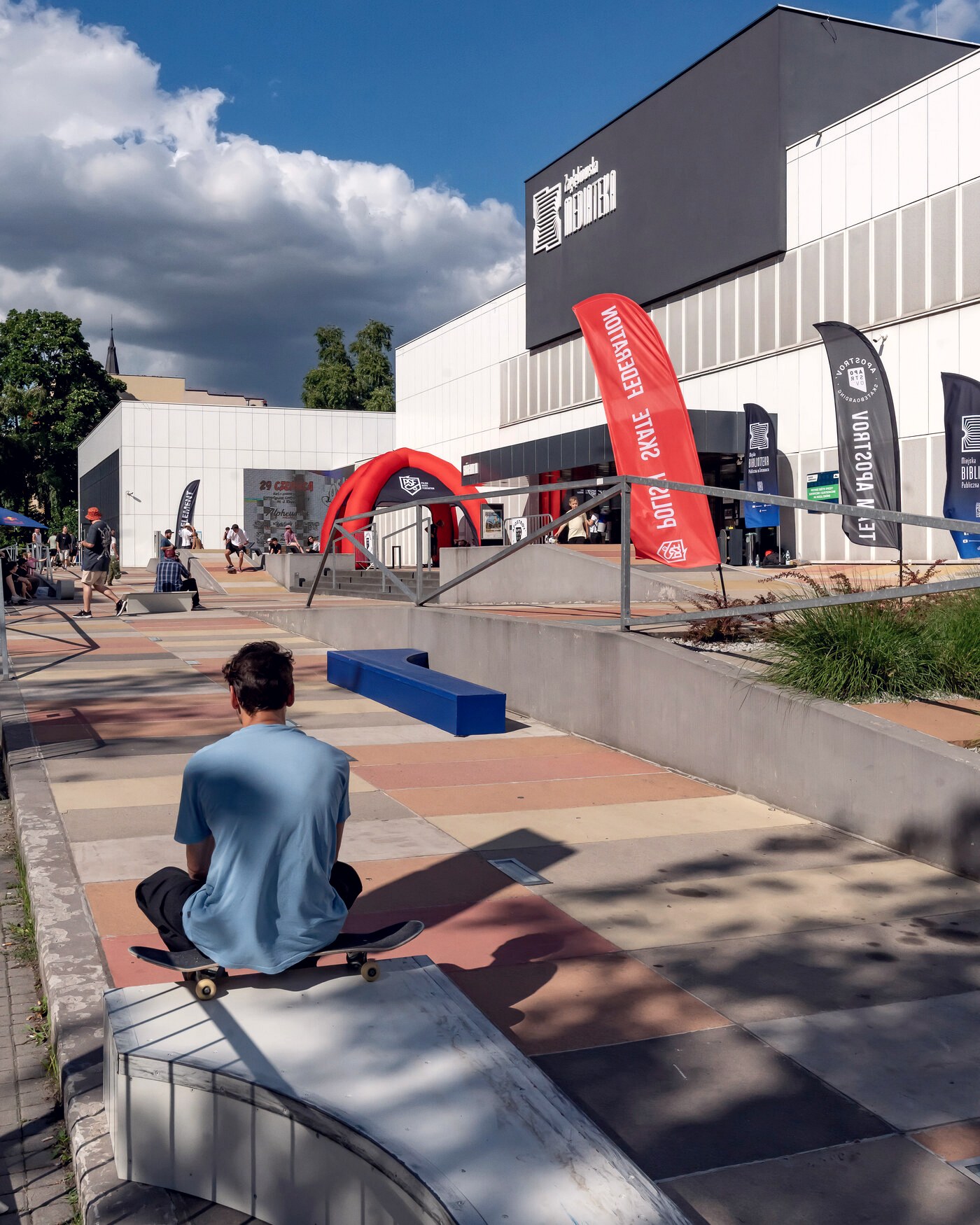 Skateur assis seul sur sa planche au bord d'un park de contest, dos tourné, avant son passage