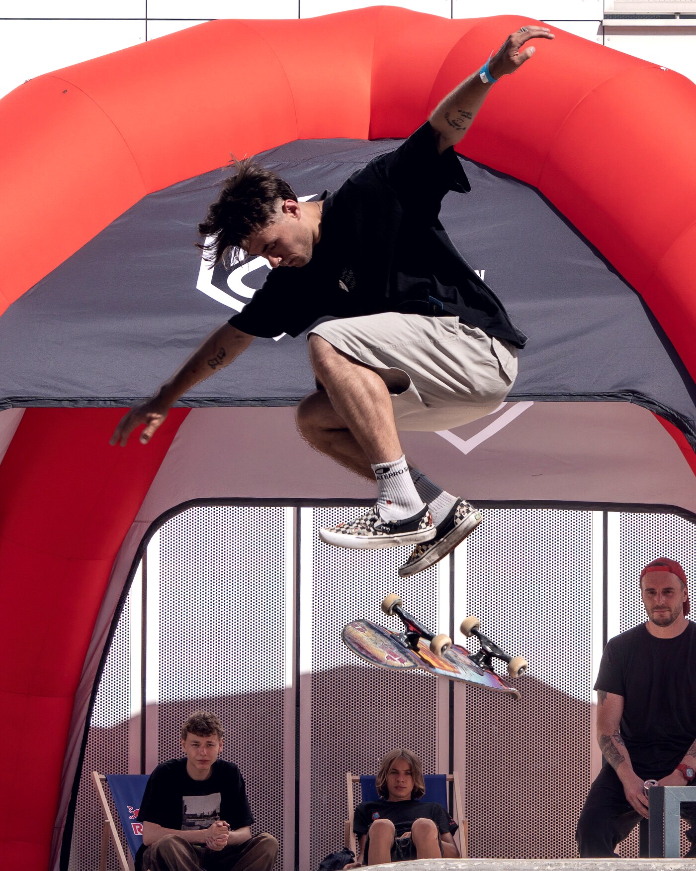 Skateur en l'air au-dessus d'un module, les juges assis juste en dessous pendant la finale d'un contest street