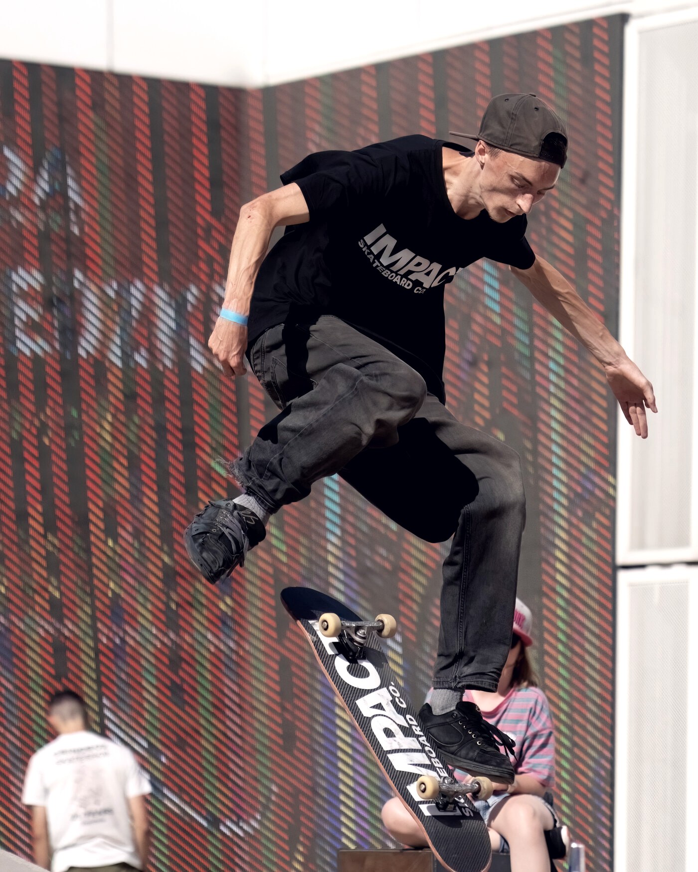 Skateur de contest en pleine figure au-dessus d'un module, jambes décollées de la planche