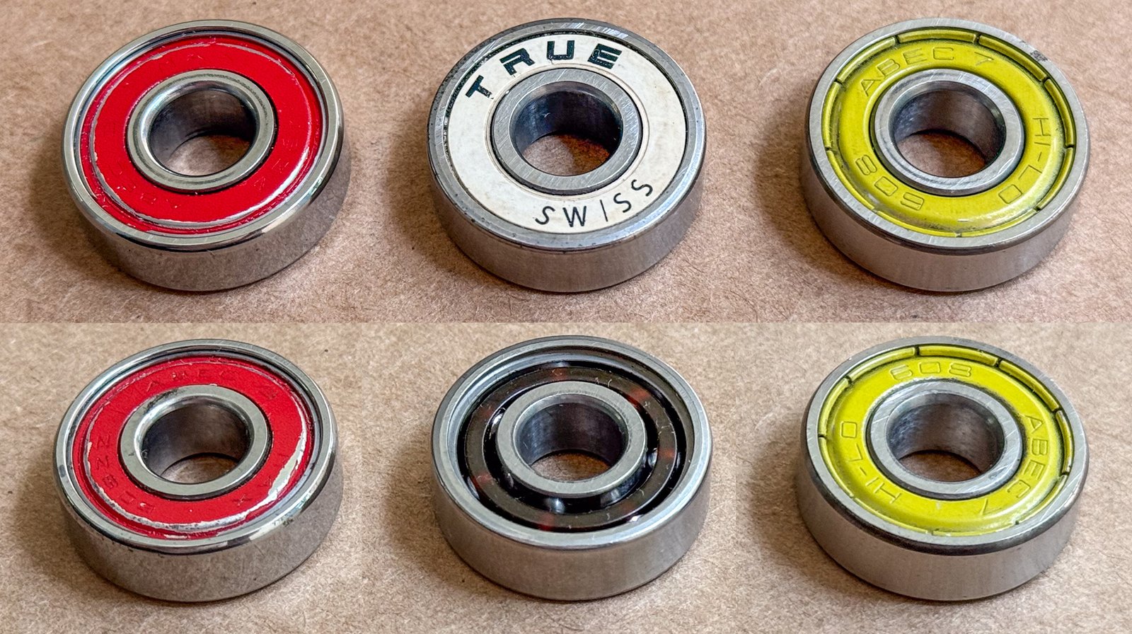 Trois roulements 608 côte à côte, recto et verso : un ABEC 3 rouge, un TRUE Swiss sans classe ABEC, un ABEC 7 jaune