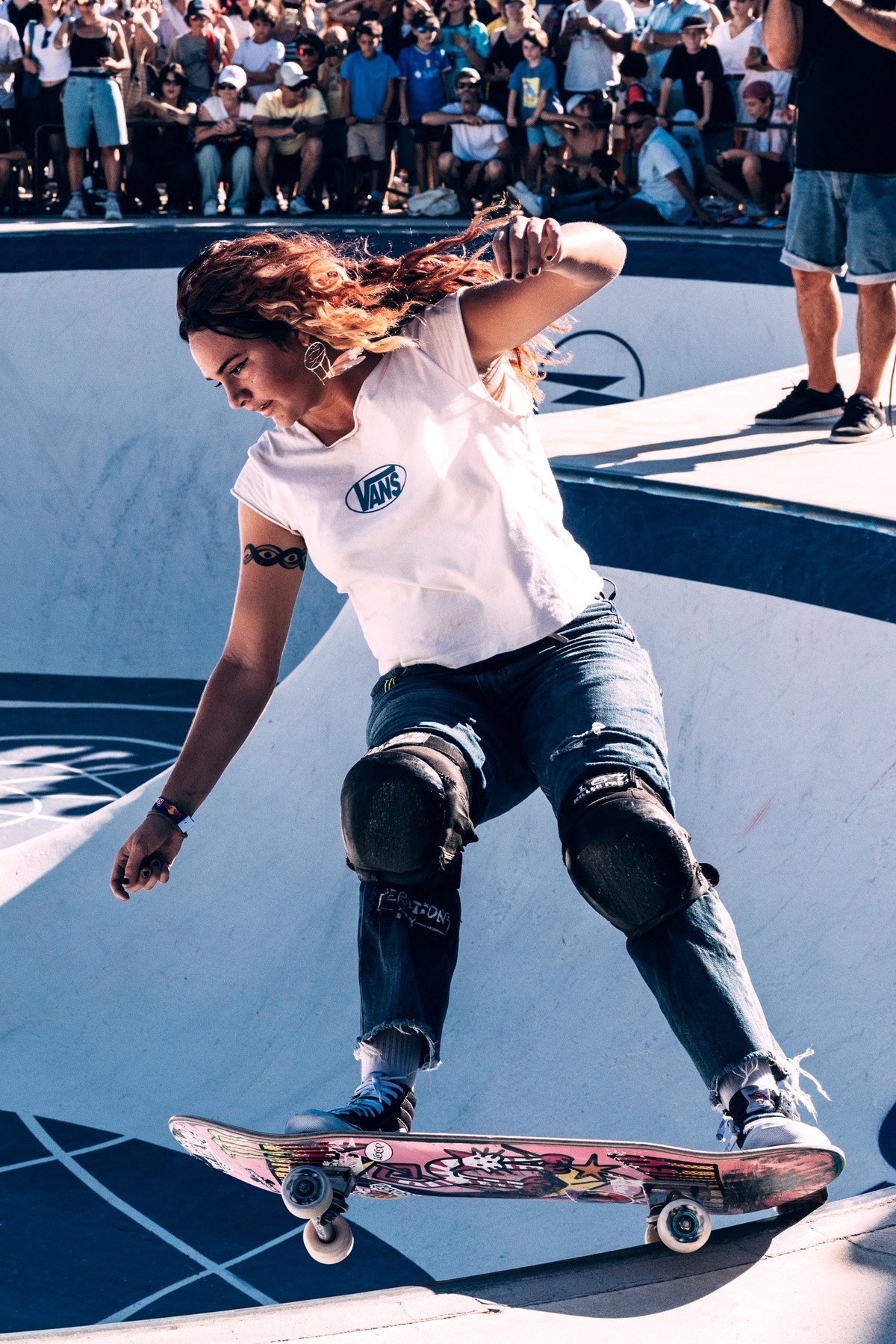 Une skateuse en plein run dans un bowl devant la foule, la concentration d'un passage de contest park