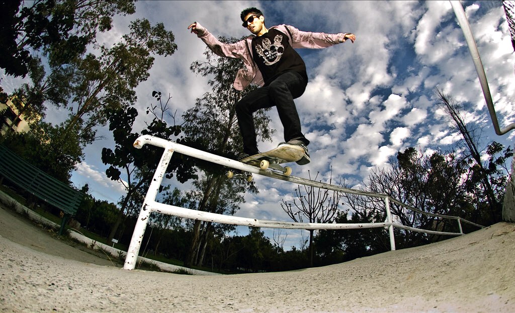 Boardslide vu d&rsquo;en bas : le milieu du deck à plat en travers de la barre pendant le slide