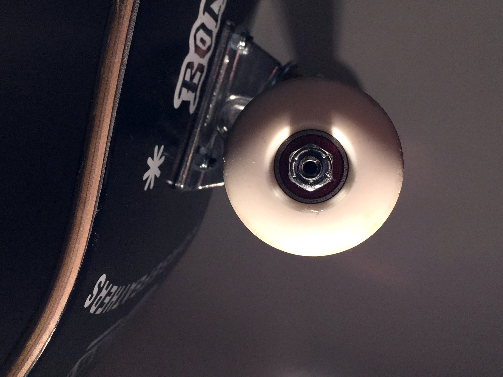 Gros plan sur une roue de skateboard et son roulement en acier monté sur l'axe du truck
