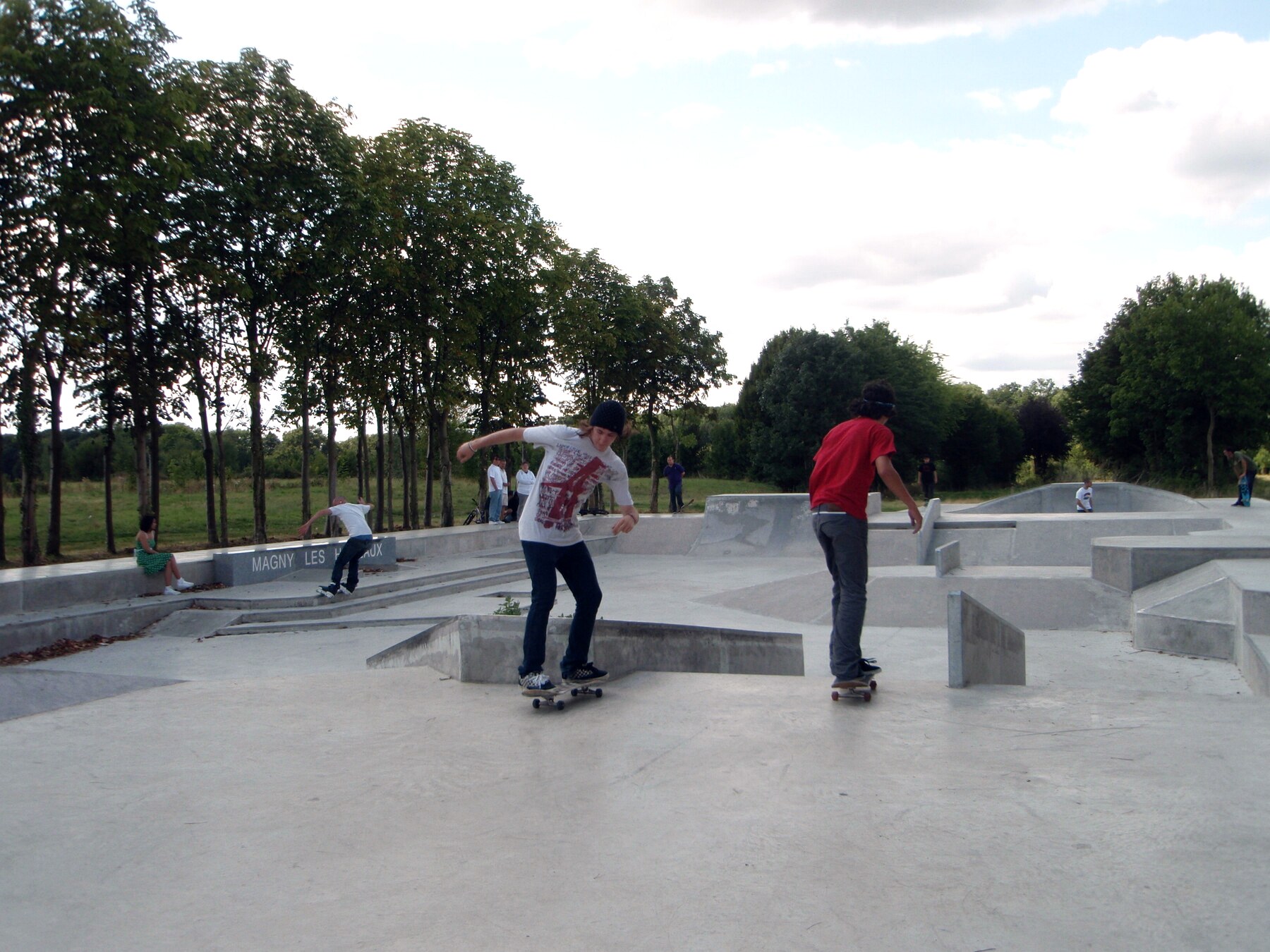 Street plaza en béton lissé à Magny-les-Hameaux : sol continu et bords nets dans une petite commune française