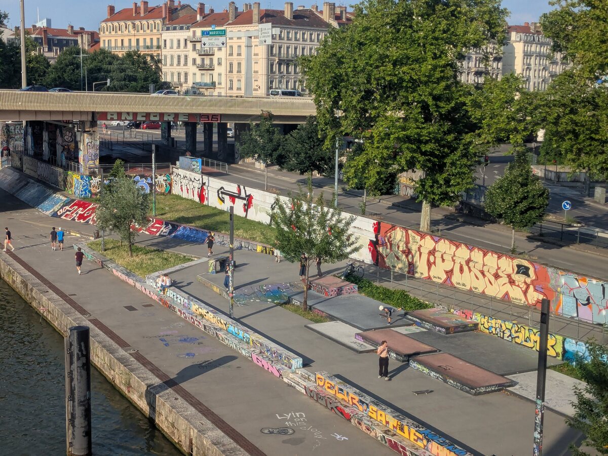 Le skatepark du quai Rambaud à Lyon vu d'en haut : 410 m² de curbs et de tables à manual tagués le long de la Saône, skateurs en session