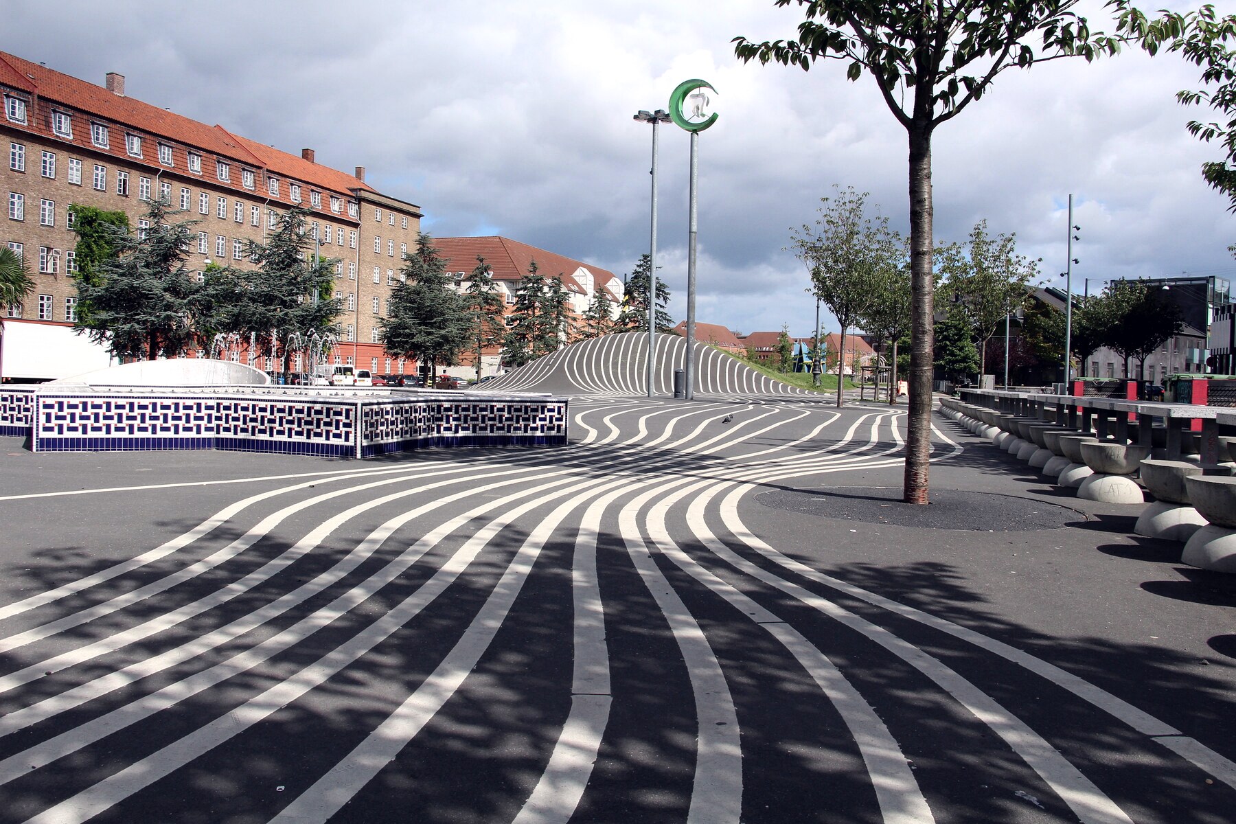 Superkilen à Copenhague : la place noire de jour, monticule de béton continu et lignes blanches, dessinée pour être roulée