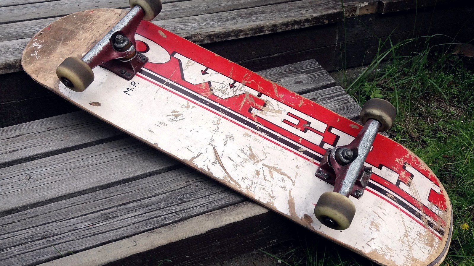 Planche de skate usée, tail rongé et bois à nu après des centaines de raclages