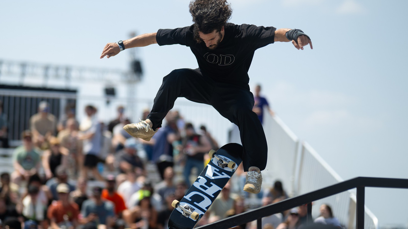 Skateur en l'air au-dessus d'un rail devant les tribunes — les quelques secondes de skate qui coûtent des semaines de tournage
