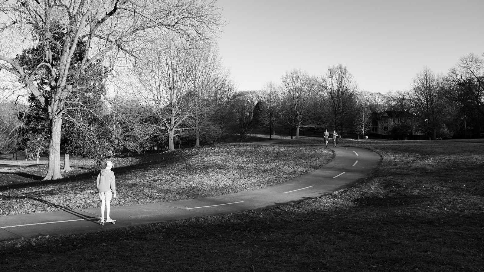 Skateur seul poussant sur une allée déserte au coucher du soleil — les heures de skate que personne ne filme en vertical