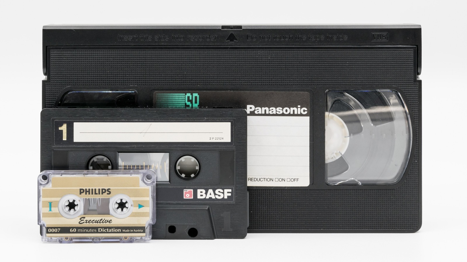 Cassette VHS et mini-cassette posées côte à côte — le format qui imposait soixante-dix minutes d'affilée