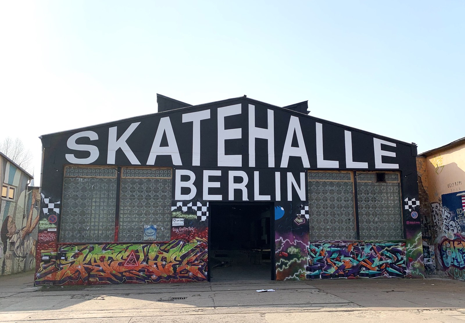 La façade noire de la Skatehalle Berlin sur le RAW-Gelände, ancien atelier ferroviaire couvert de graffitis